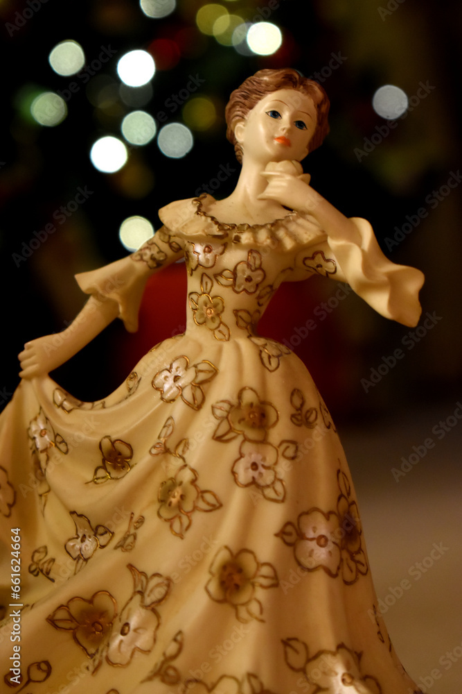 A beautiful angel doll stands on bokeh lights blurred background. Decoration on Christmas holidays.