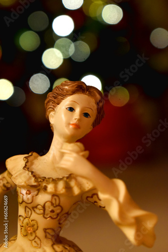 Close-Up of a angel doll  on bokeh lights blurred background. Decoration on Christmas holidays. Doll on the background of the christmas tree.