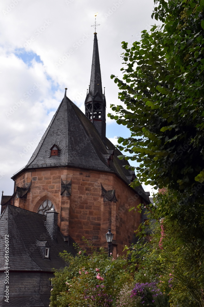 Fototapeta premium Kugelkirche in Marburg hinter blühenden Vorgärten