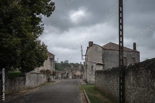 Fototapeta Naklejka Na Ścianę i Meble -  View of a paved street of an old ghost town, it is destroyed and abandoned since the war