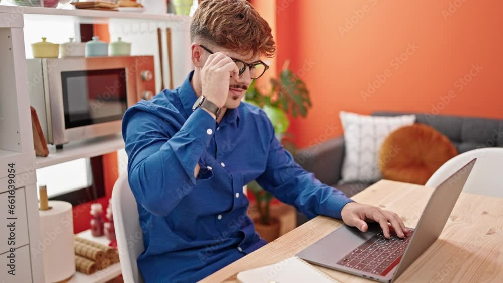Young hispanic man using laptop taking glasses off smiling at dinning room Young hispanic man using laptop taking glasses off smiling at dinning room