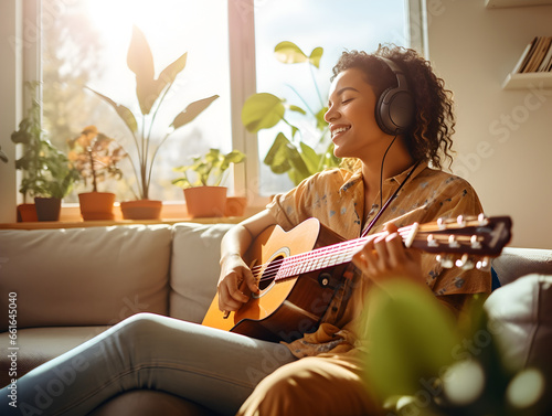 Frau spielt Zuhause entspannt Gitarre, Zuhause musizieren photo