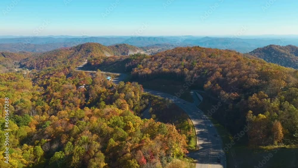High point of view of highway route in North Carolina through Appalachian mountains in golden fall season with fast moving trucks and cars. Interstate transportation concept High point of view of highway route in North Carolina through Appalachian mountains in golden fall season with fast moving trucks and cars. Interstate transportation concept