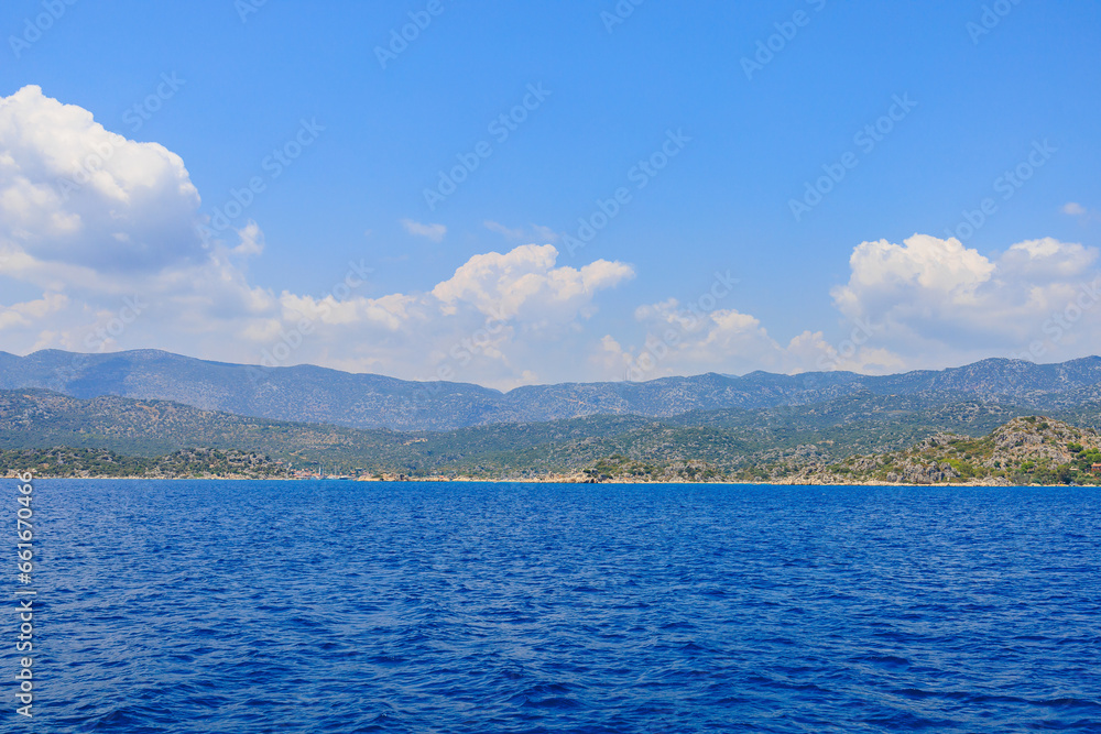 Obraz premium View of the rocky shore from the sea. Mediterranean Sea in Turkey. Popular tourist places. Background