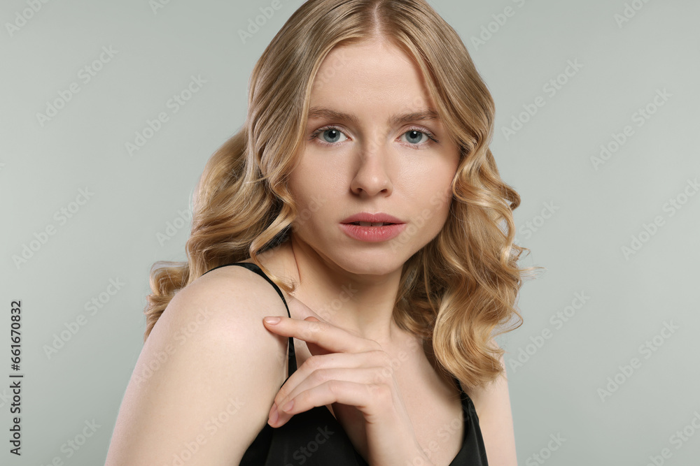Naklejka premium Portrait of beautiful woman with blonde hair on light grey background