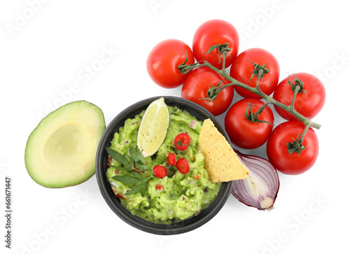 Delicious guacamole with nachos chips, lime and different ingredients isolated on white, top view