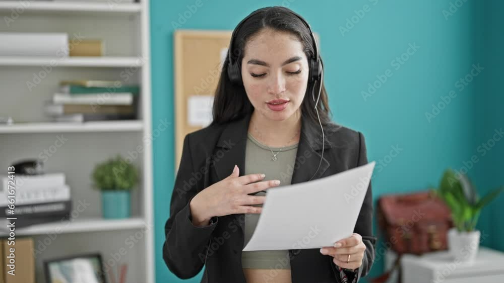 Young beautiful hispanic woman business worker reading document having free hands call at the office Young beautiful hispanic woman business worker reading document having free hands call at the office