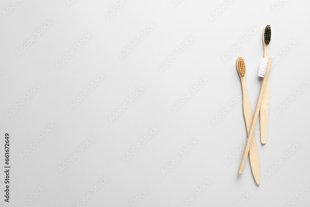 Bamboo toothbrushes on white background, flat lay. Space for text Bamboo toothbrushes on white background, flat lay. Space for text