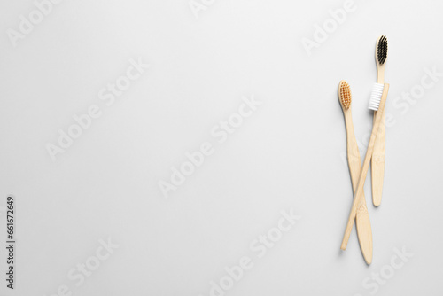Bamboo toothbrushes on white background, flat lay. Space for text © New Africa