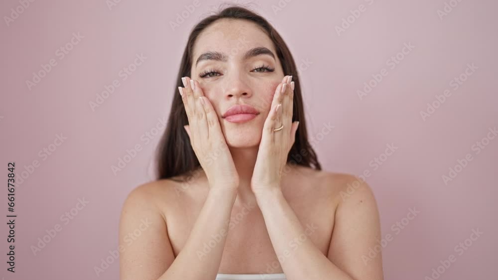 Young beautiful hispanic woman smiling confident massaging face over isolated pink background Young beautiful hispanic woman smiling confident massaging face over isolated pink background