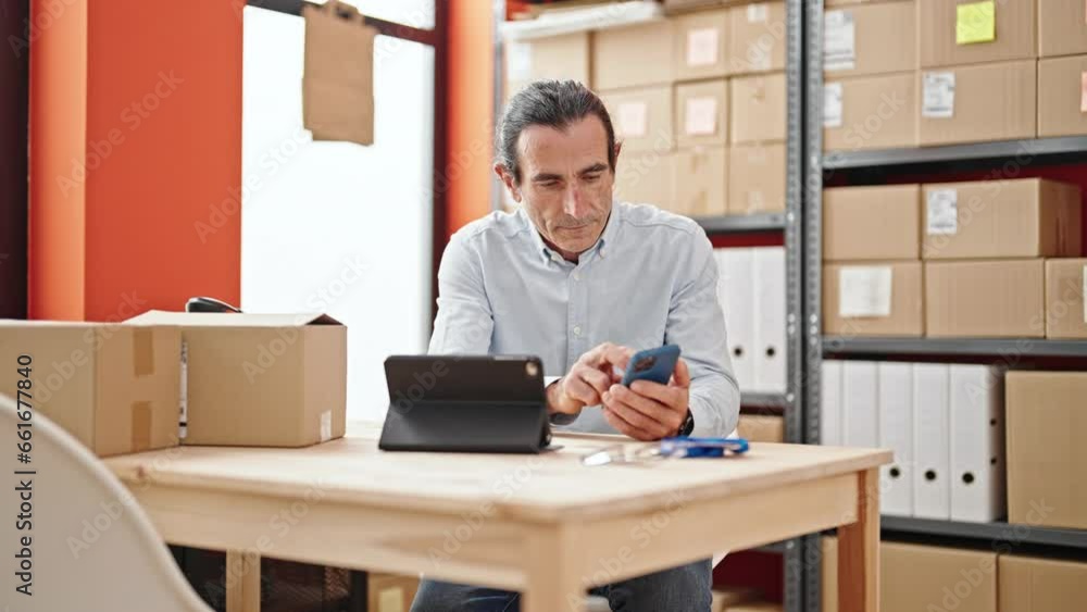 Middle age man ecommerce business worker using touchpad and smartphone at office Middle age man ecommerce business worker using touchpad and smartphone at office