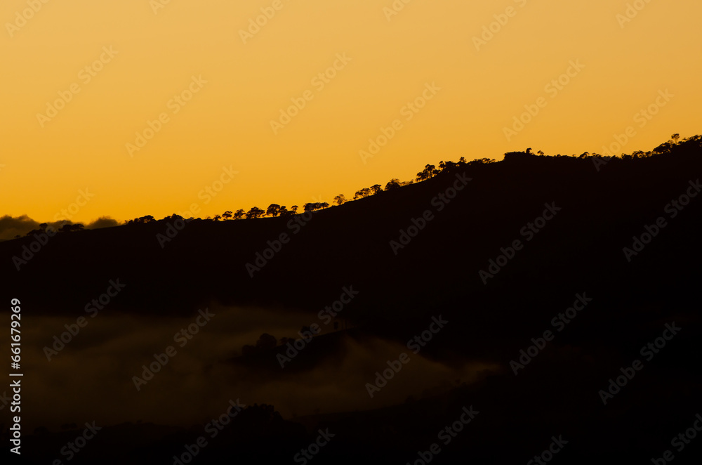 Landscape of sunset on the mountain with backlit tree lines Landscape of sunset on the mountain with backlit tree lines
