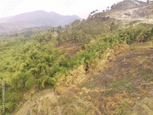 Aerial Photography. Aerial Drone view of the barren and dry landscape of Mount Pangradinan, Cikancung - Bandung, Indonesia. A barren mountain and a source of mining for local resident
