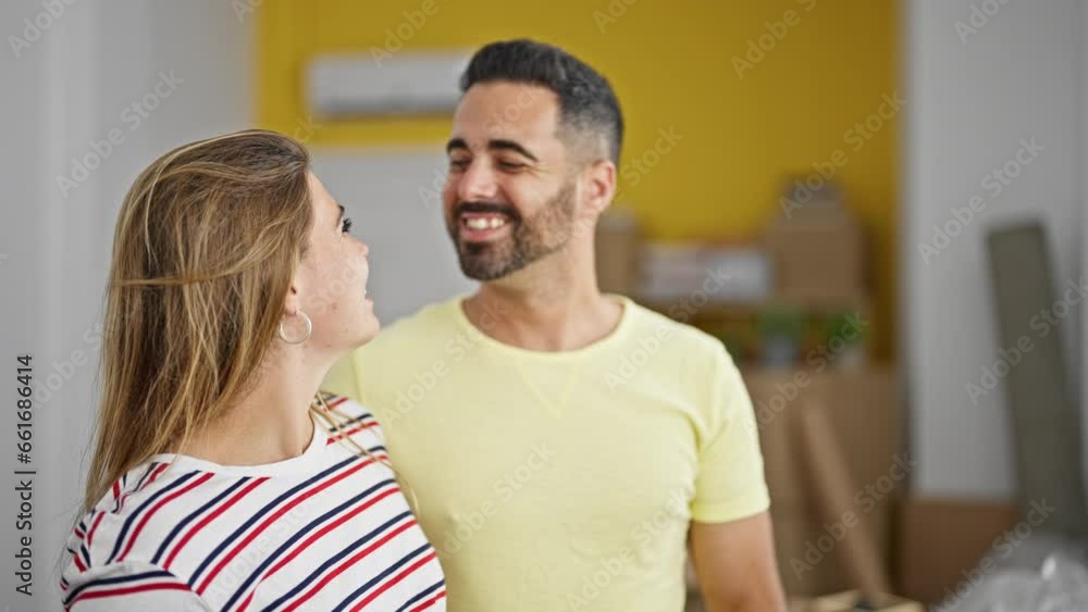 Man and woman couple standing together looking to the side at new home Man and woman couple standing together looking to the side at new home