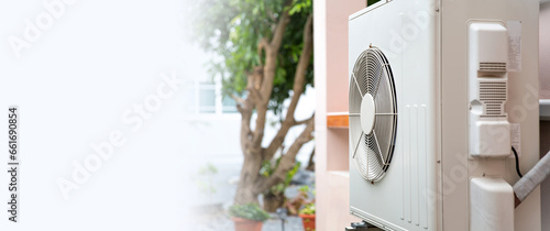 Air compressor external split wall type of outdoor home air conditioner unit installed on outside building. Concepts of cool or heat or hot and air conditioning system maintenance service cleaning.