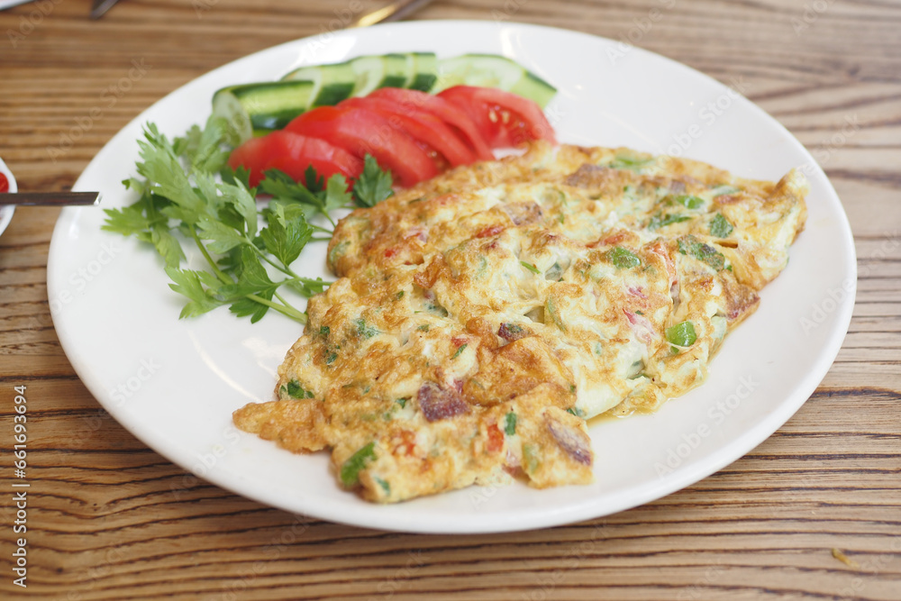Plain Egg Omelette and fresh salad for breakfast on table Plain Egg Omelette and fresh salad for breakfast on table
