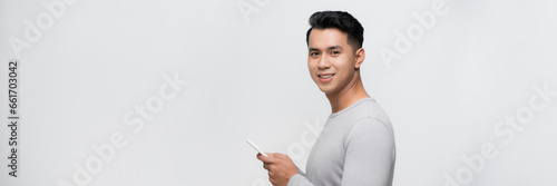 Image of smiling young man using mobile phone isolated by white background