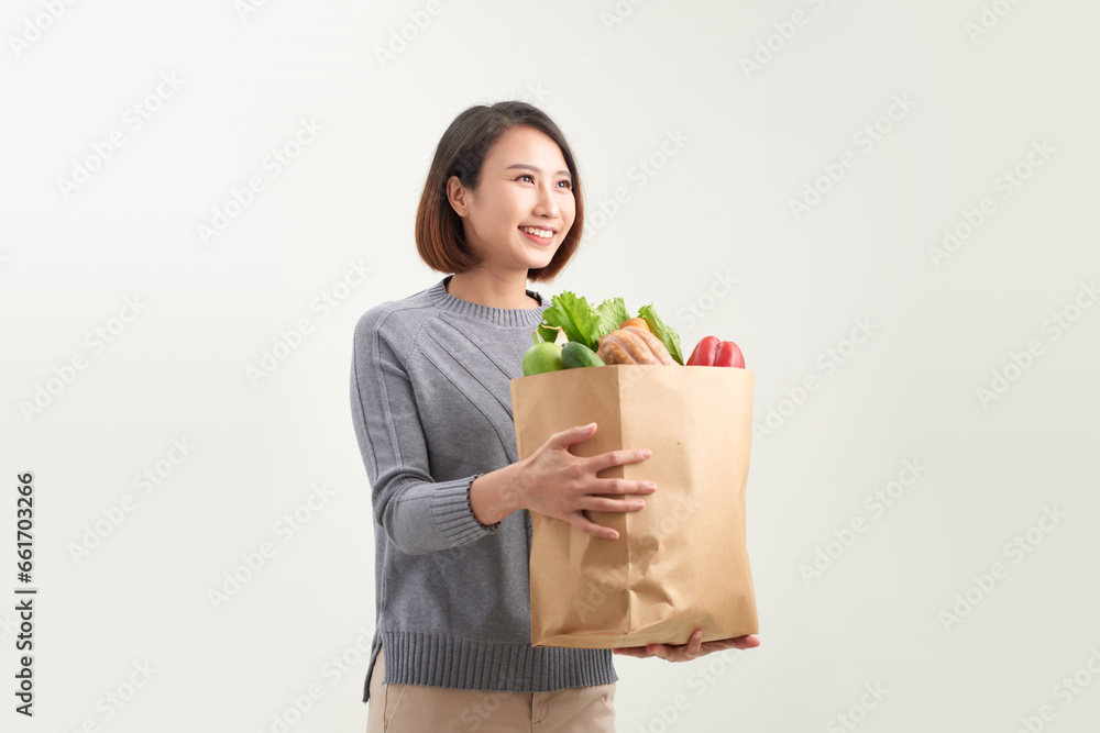 Young asian girl in sweater with groceries isolated. Young asian girl in sweater with groceries isolated.