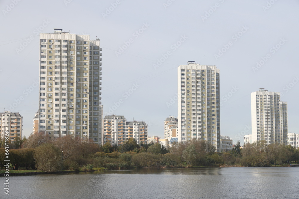 View of residential buildings on the shore of a pond in a landscape park, Yuzhnoye Butovo, Moscow, October 2023.