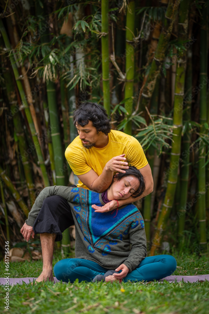 Thai massage therapy session, outdoors with bamboo background