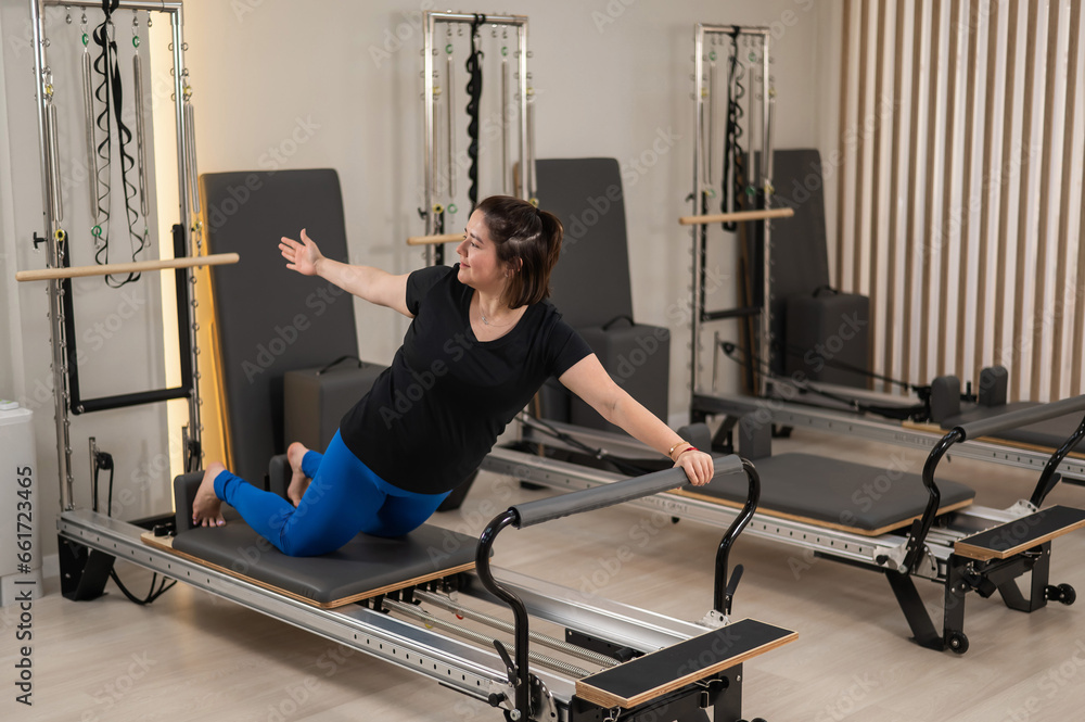 Foto de Overweight caucasian woman doing pilates exercises on a