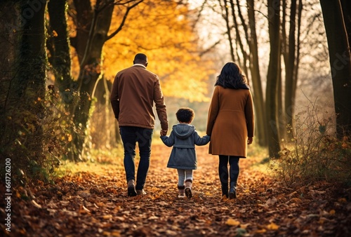 family walking in park autumn leaves on ground and trees. AI Generated Images