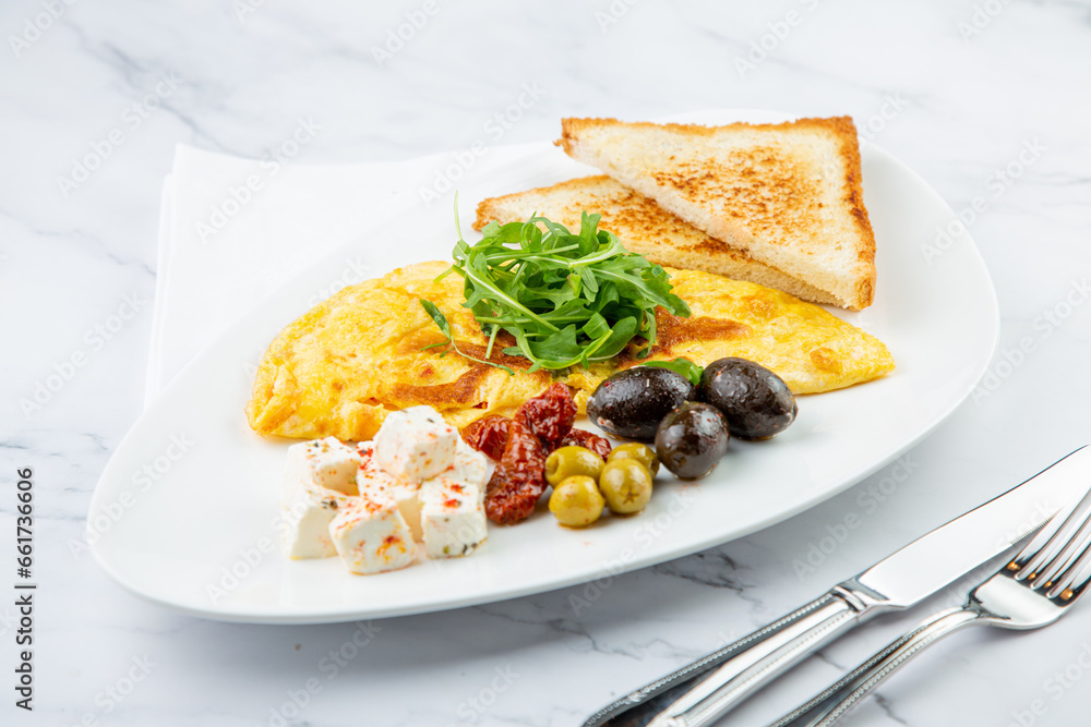 Breakfast of eggs with meat, herbs and drops of sauce with bread in a round plate side view Breakfast of eggs with meat, herbs and drops of sauce with bread in a round plate side view