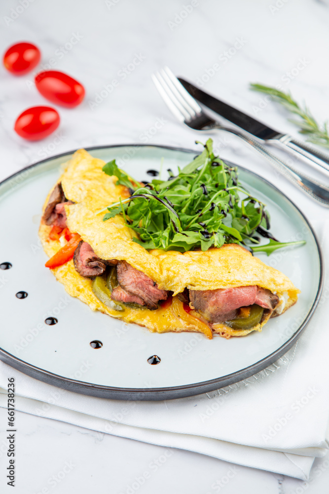 Breakfast of eggs with meat, herbs and drops of sauce in a round plate side view