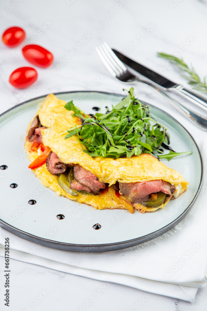 Breakfast of eggs with meat, herbs and drops of sauce in a round plate side view Breakfast of eggs with meat, herbs and drops of sauce in a round plate side view