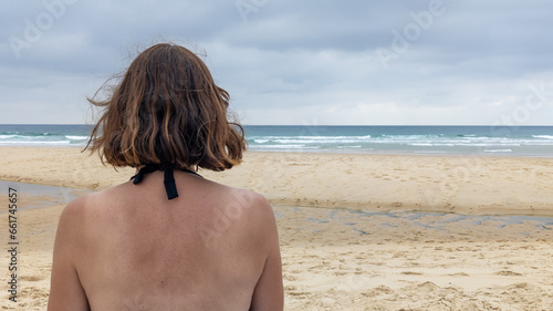 rear slim woman enjoying beach vacation by sea atlantic in Gironde Lacanau Ocean France
