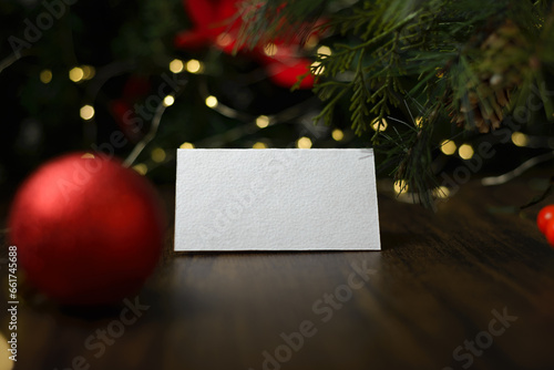 Blank invitation card on wooden table with Christmas ornaments. Blank business card mockup.