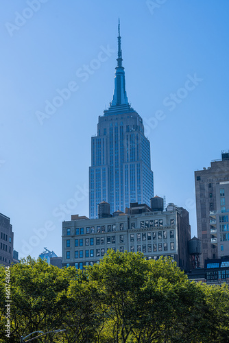View of empire state building from bryant park in new york city at middle of the day