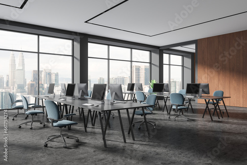 Stylish business coworking interior with pc monitors and chairs  window