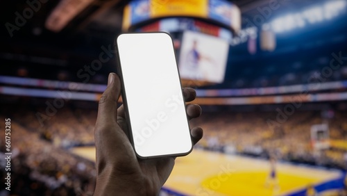 Photography CU African-American Black male using phone during basketball game