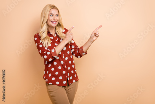 Photo of young woman marketologist target fingers indicate mockup message good news brand sale offer isolated on beige color background photo