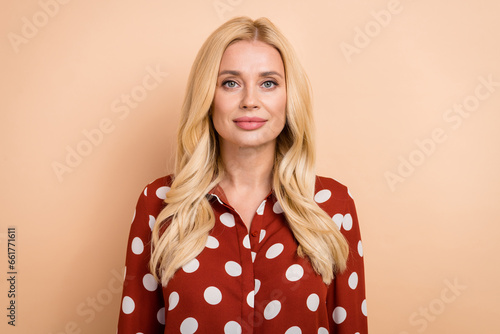 Portrait photo of young confident business lady wear dotted red shirt serious face serious company owner isolated on beige color background © deagreez