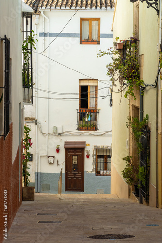 Fototapeta Naklejka Na Ścianę i Meble -   Narrow street with white old houses, spanish mediterranean town, in Teulada (Alicante, Spain).