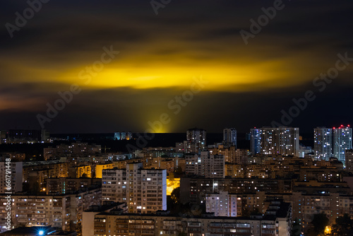 Light pollution of nature - glow in night clouds over a city with multi-storey buildings, the problem of urbanization and ecology