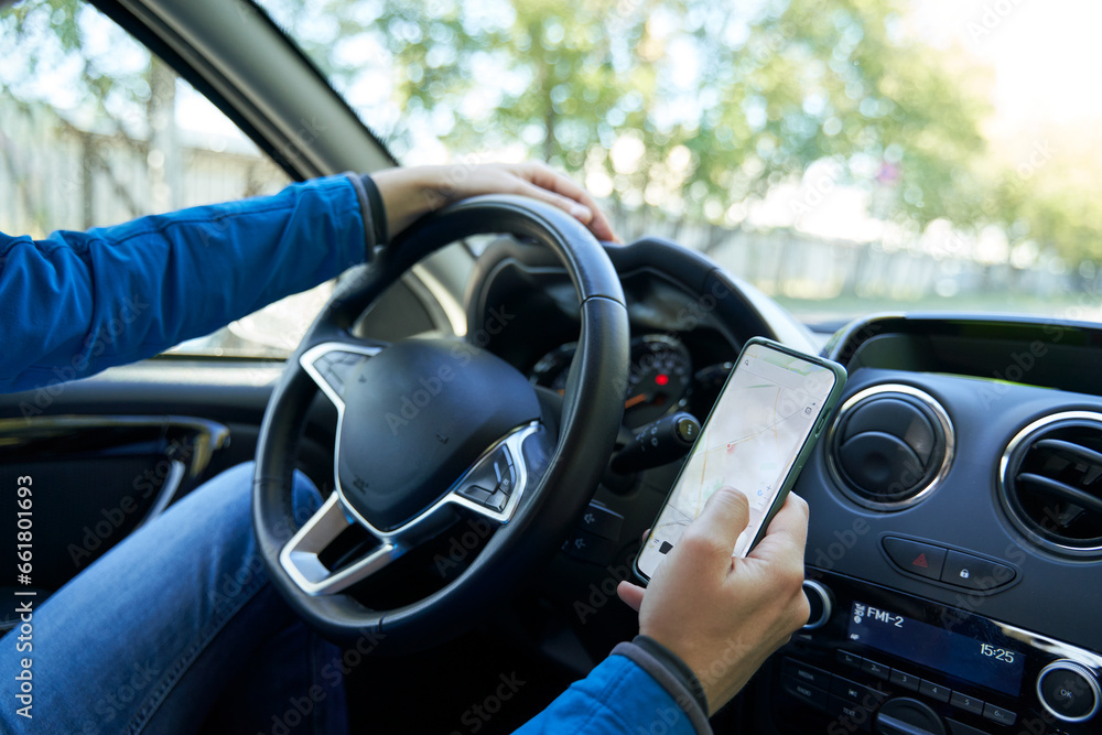 Man driving car using smartphone in motion.