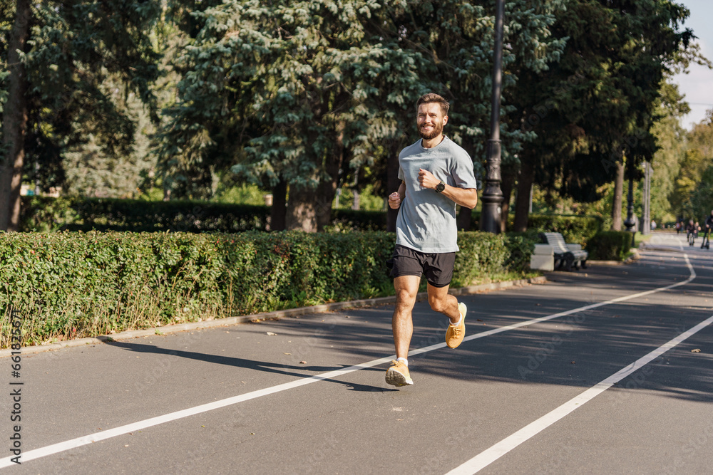 Fototapeta premium Training development of the cardiac system. Warm-up runner happy uses sportswear. A hardy young man exercises alone. Slim body and active lifestyle.