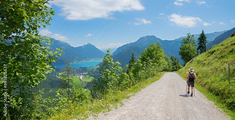hiker at route to Feilkopf mountain, view to lake Achensee and tirolean alps - obrazy, fototapety, plakaty 