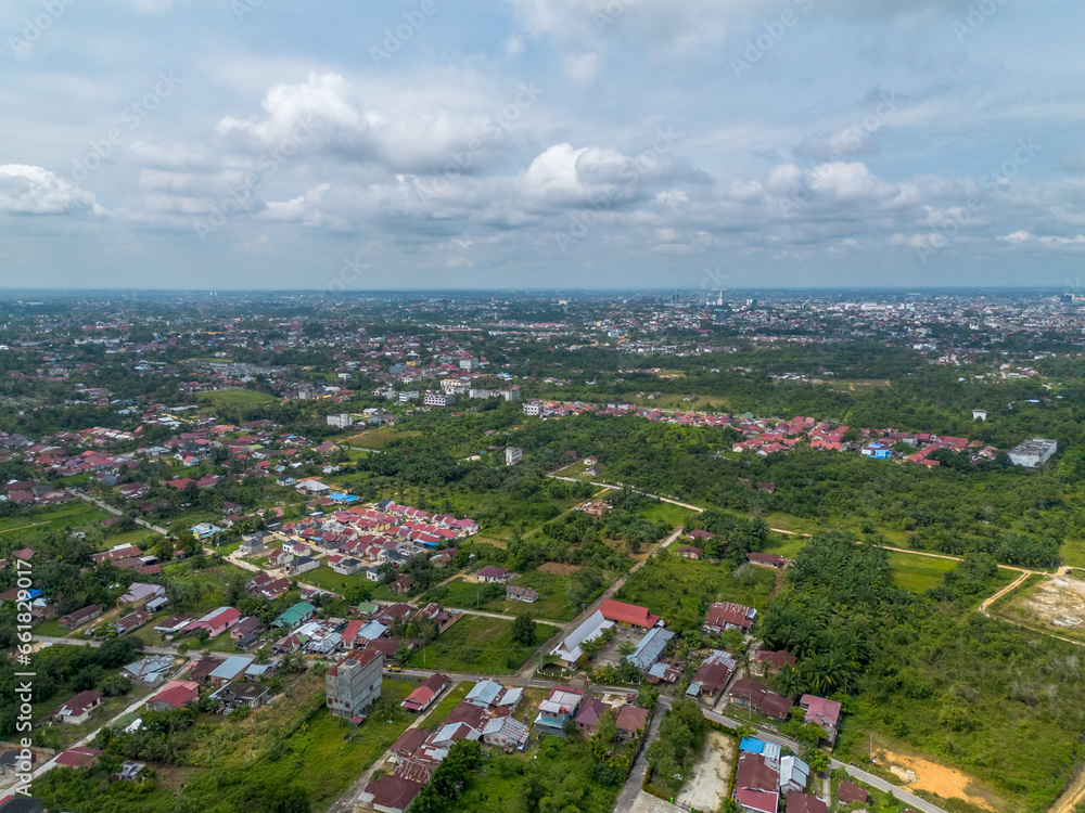 Aerial View of Pekanbaru city skyline with many trees in Indonesia. The capital city of Riau province with many residential buildings.