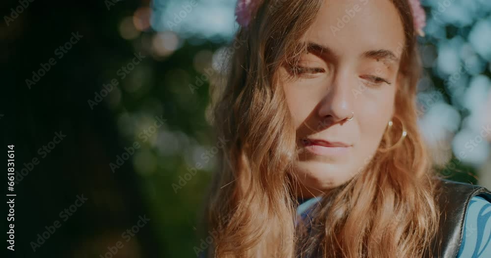 Young woman looking down in park on sunny day Young woman looking down in park on sunny day