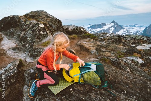 Child girl hiking with backpack in mountains travel family vacations in Norway adventure outdoor active healthy lifestyle 4 years old kid