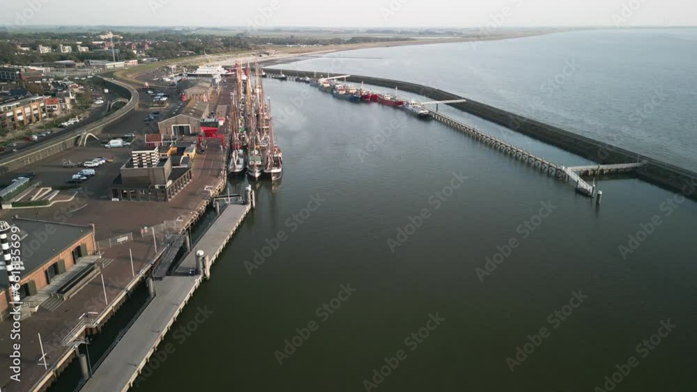 Many mast ships tied to each other sit on a pier in the small town of Harlingen. Quiet harbor, calm sea, sunset.pier where old mast ships are moored, view from a drone at sunset. History of seafarers Many mast ships tied to each other sit on a pier in the small town of Harlingen. Quiet harbor, calm sea, sunset.pier where old mast ships are moored, view from a drone at sunset. History of seafarers