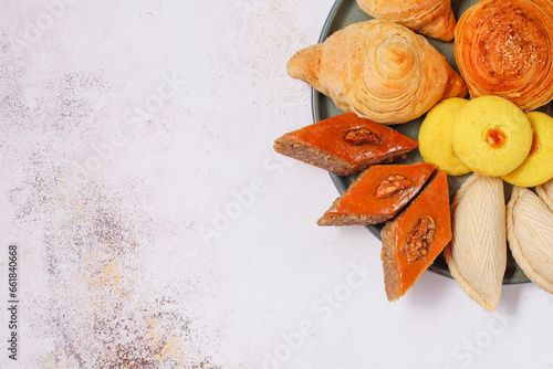 Traditional Azerbaijan holiday Novruz background with green semeni,traditional azerbaijan sweets,shekerbura,qogal,paxlava,mutaki and different nuts and sweets,top view,space for copy