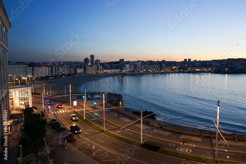 Vista de la playa de Riazor y Matadero en la ciudad de A Coruña al atardecer en una noche cálida de verano con el cielo despejado sin nubes alrededor photo
