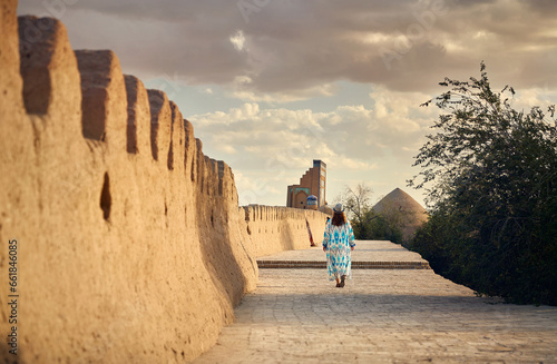 Tourist in ethnic dress at city walls Ichan Kala of Khiva