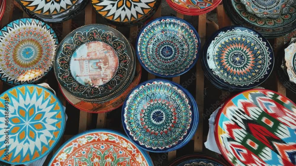 Uzbek national ceramic tableware in Tashkent - June 29, 2023: Goods at the Oriental Bazaar in Uzbekistan. Chorsu Market. Plates, teapots, cups. Painting with floral ornament. 4K
