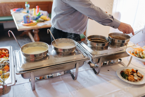Different sauces in silver pots at a wedding buffet 